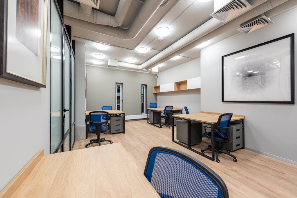 Contemporary office interior with desks, chairs, and abstract art. Ideal for business settings.